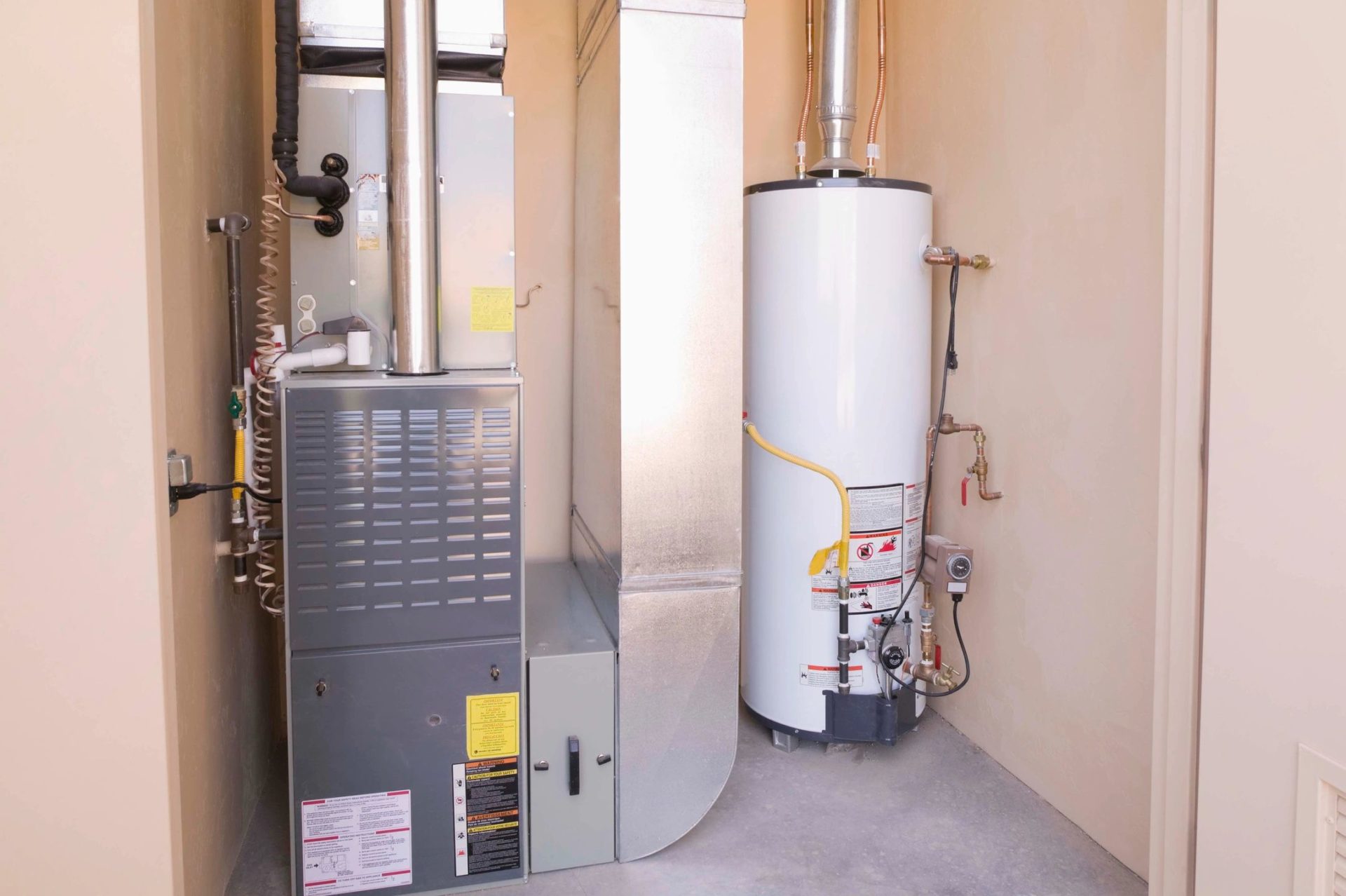 A gas furnace and water heater in the corner of a room.